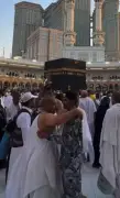 رجل أمن بالحرم المكي يحتضن معتمراً بلطف وسط الزحام في مشهد يعكس عناية المملكة بضيوف الرحمن